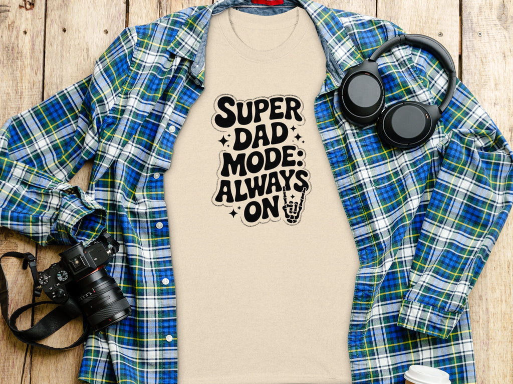 T-shirt with "Super Dad Mode: Always On" text and skeleton hand, worn with a plaid shirt.