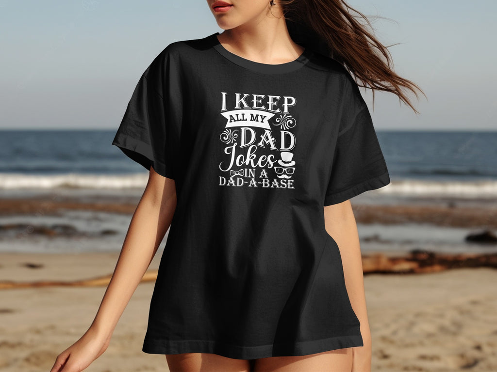 Black t-shirt with white text "I KEEP ALL MY DAD Jokes IN A DAD-A-BASE".