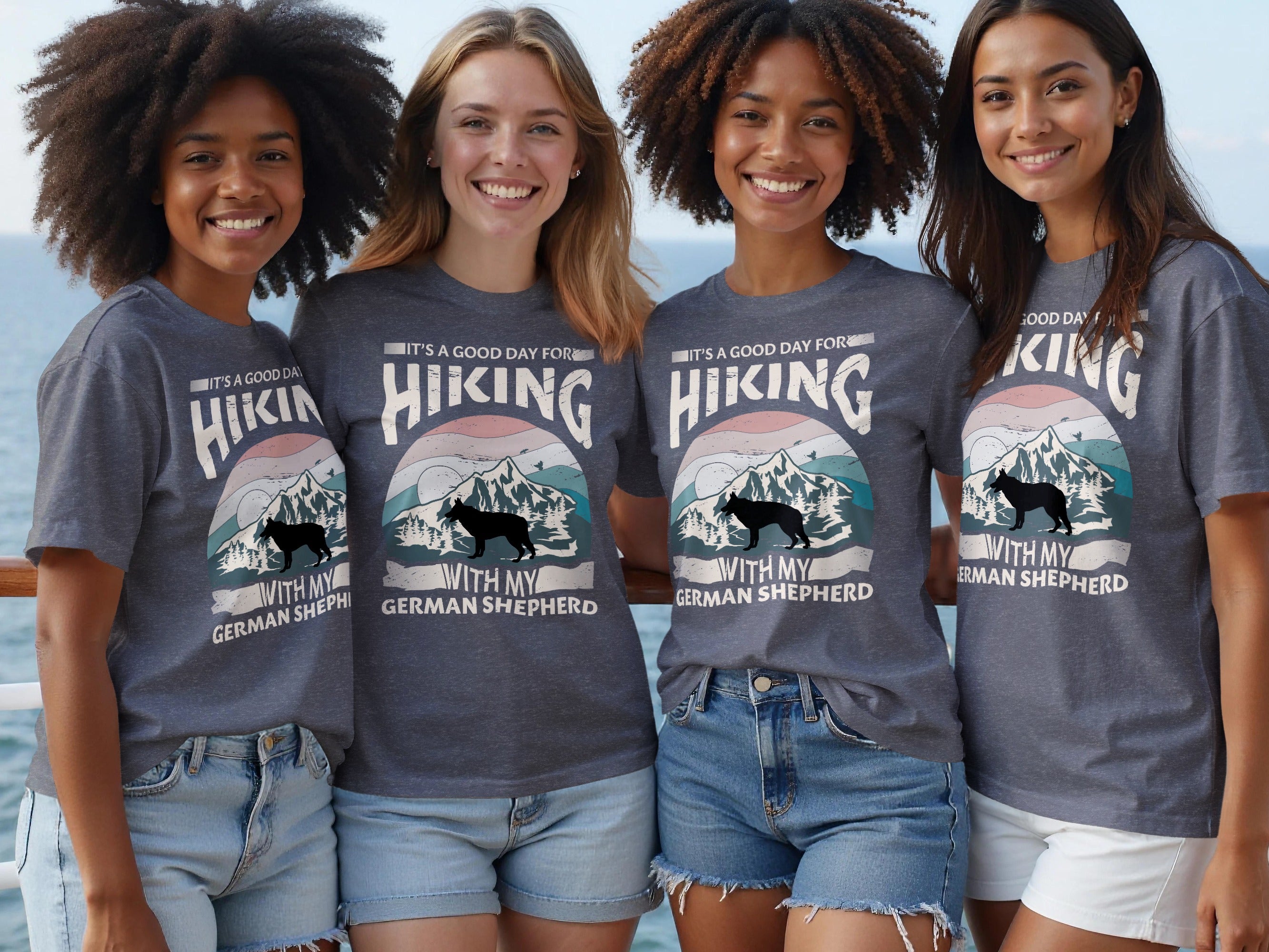 Four women wear matching t-shirts with a German Shepherd and mountain graphic.