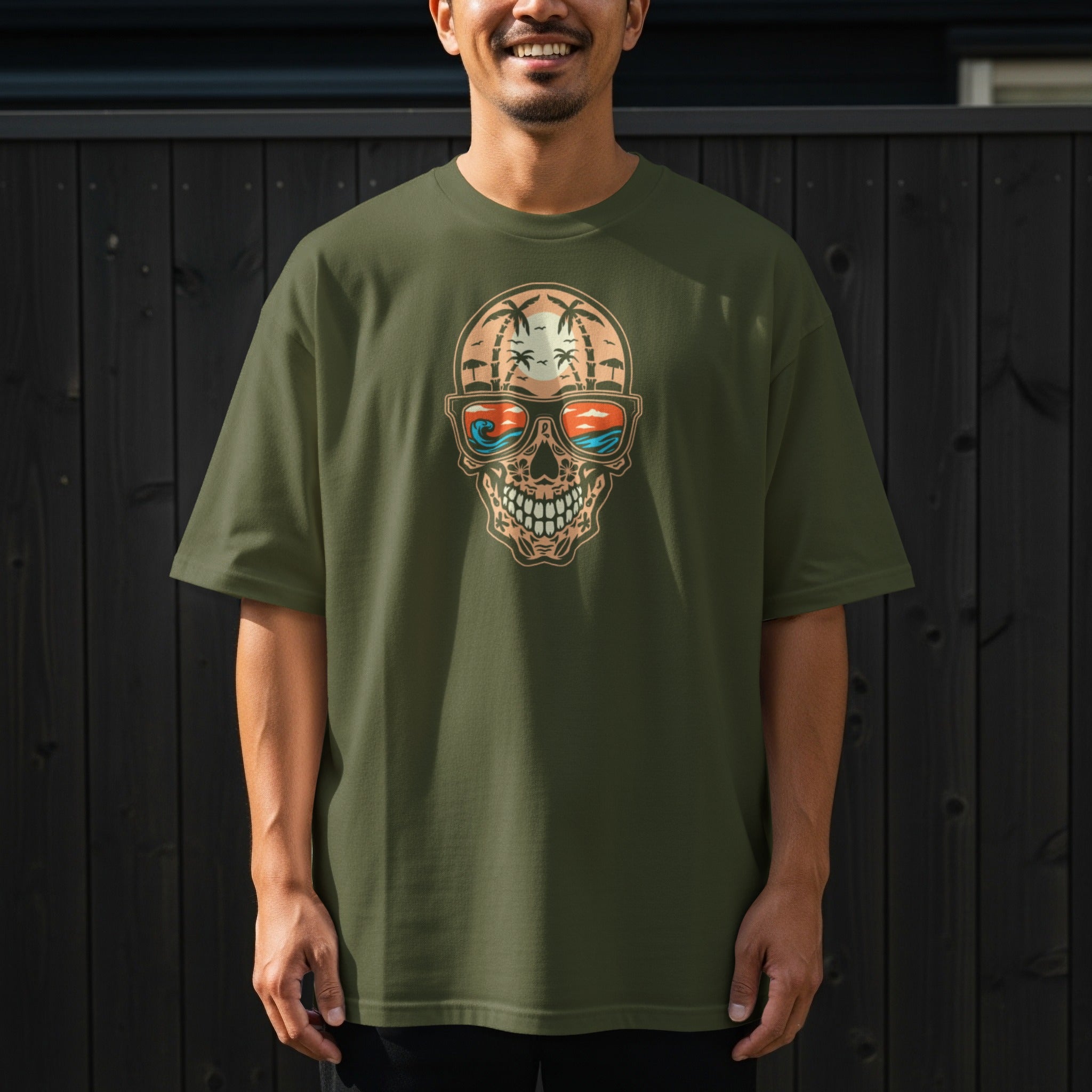 Green t-shirt with a skull graphic wearing sunglasses reflecting a tropical beach scene.