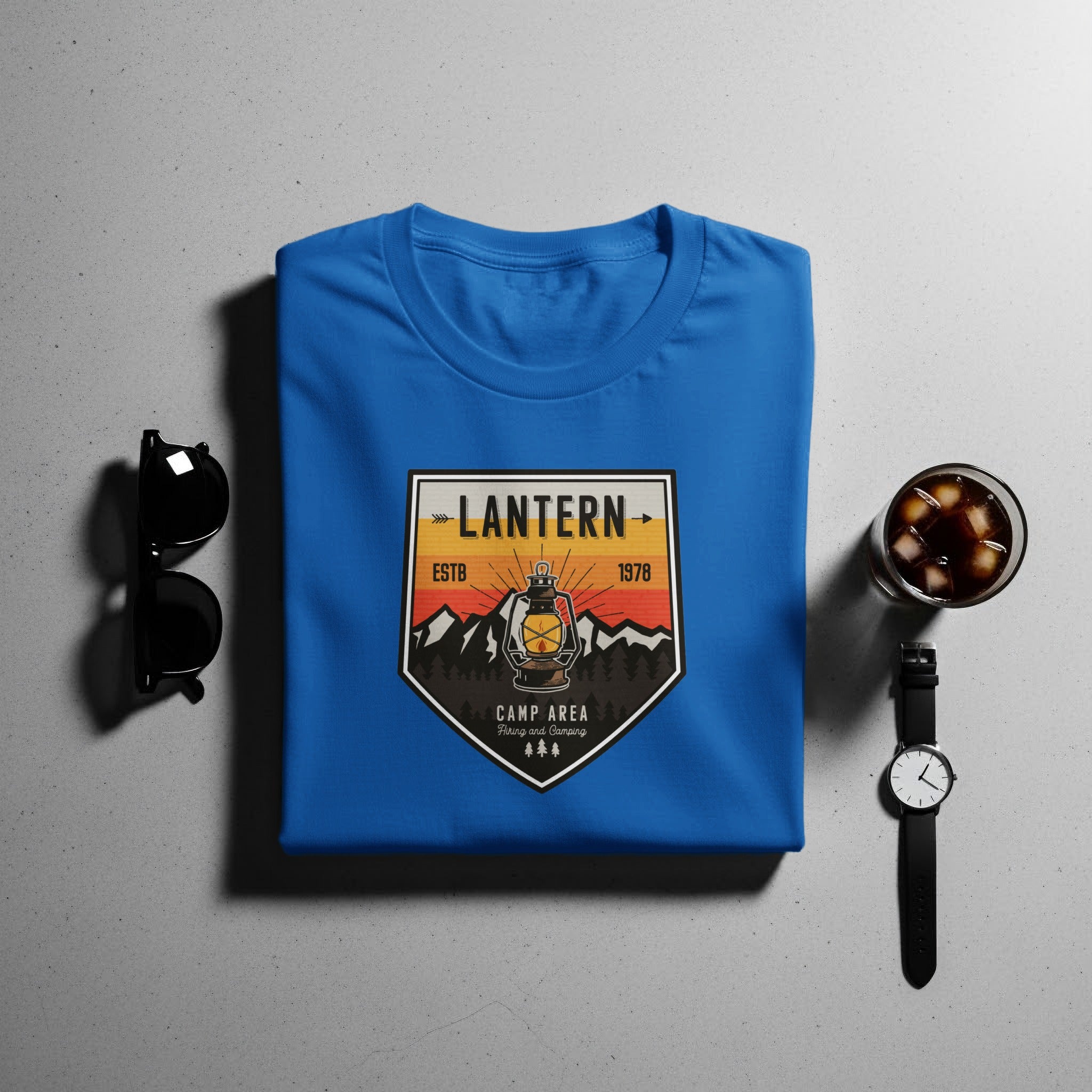 Blue t-shirt with a "Lantern Camp Area" graphic featuring a lantern, mountains, and trees.