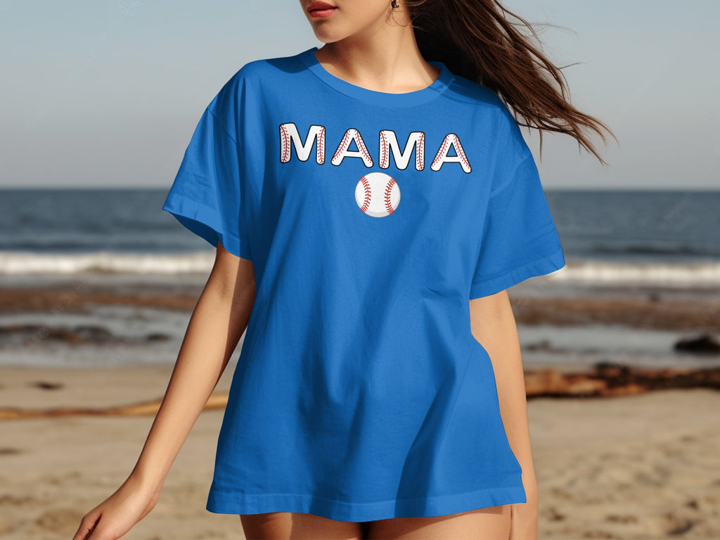 Blue t-shirt with "MAMA" text and baseball graphic on a beach background.