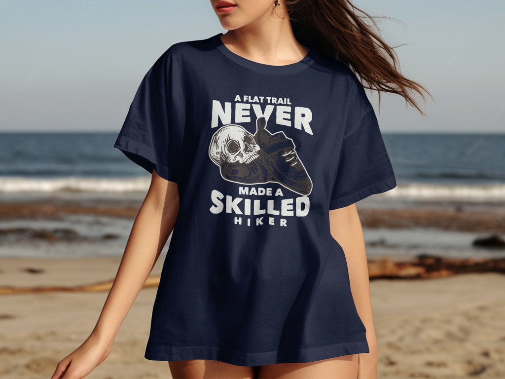 Navy t-shirt with skull and hiking boot graphic and text "A flat trail never made a skilled hiker".