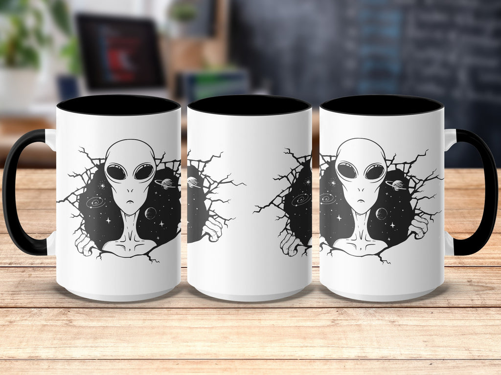 White mug with black interior and handle, featuring an alien breaking through a starry galaxy.