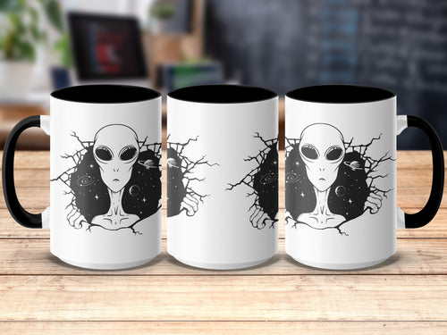White mug with black interior and handle, featuring an alien breaking through a starry galaxy.