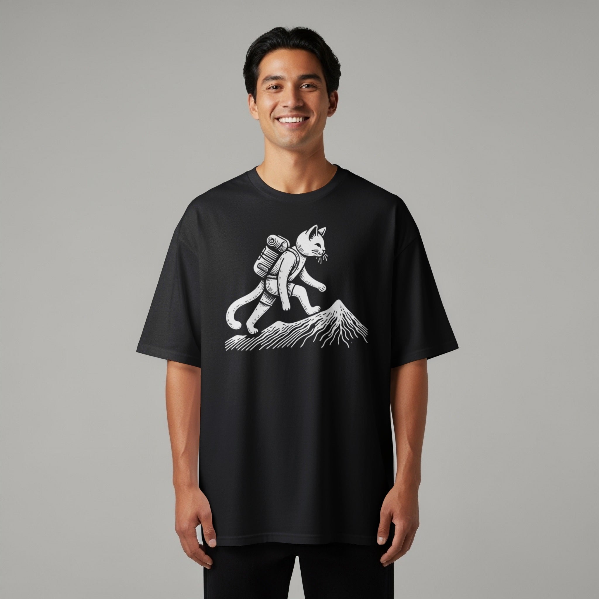 Black t-shirt with a white graphic of a cat hiking up a mountain.