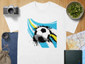 White t-shirt with abstract soccer ball graphic and blue and yellow brush strokes.