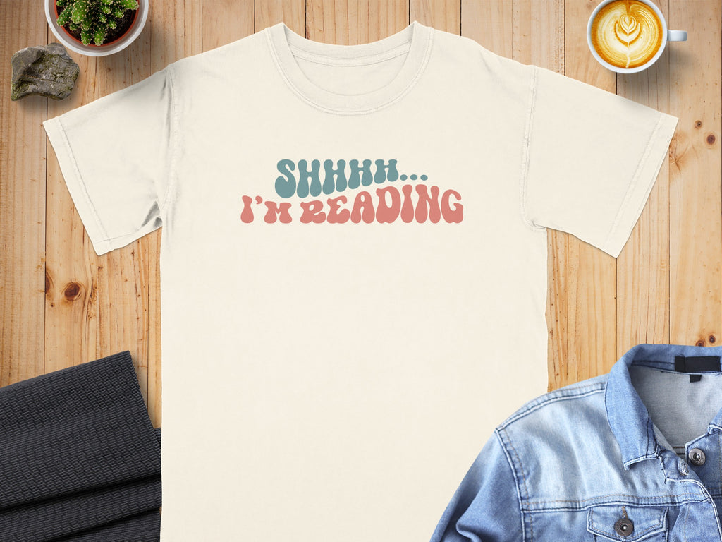 Cream t-shirt with "SHHHH... I'M READING" in retro font.