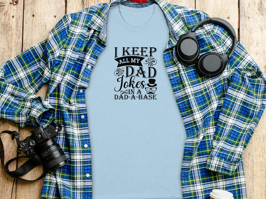 Light blue t-shirt with "I Keep All My Dad Jokes In A Dad-a-base" text design.