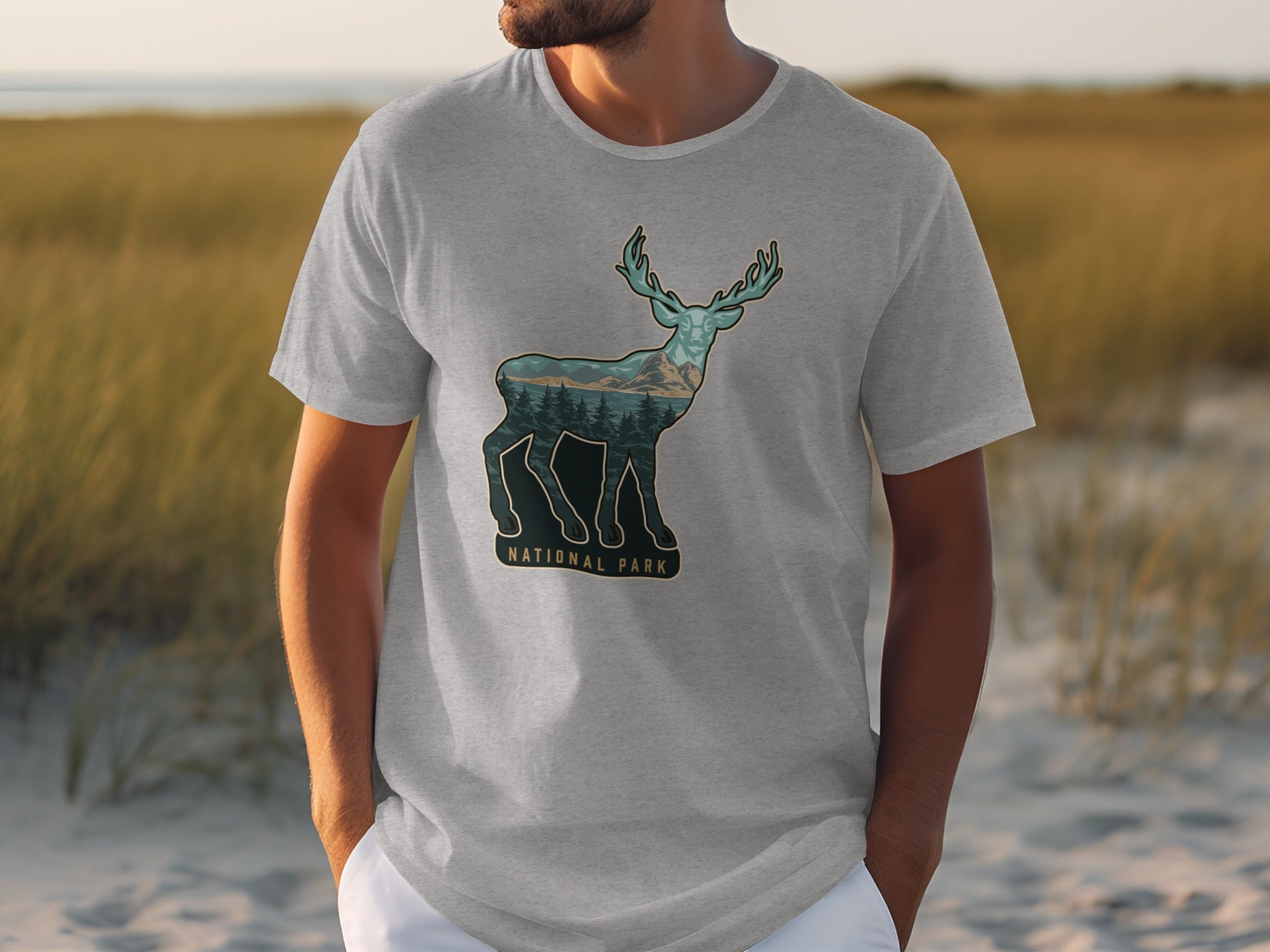 Grey t-shirt with a deer silhouette filled with a mountain and forest landscape.