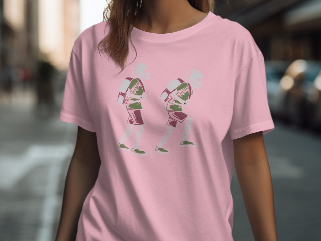 Pink t-shirt with a graphic of two skeleton figures carrying backpacks.