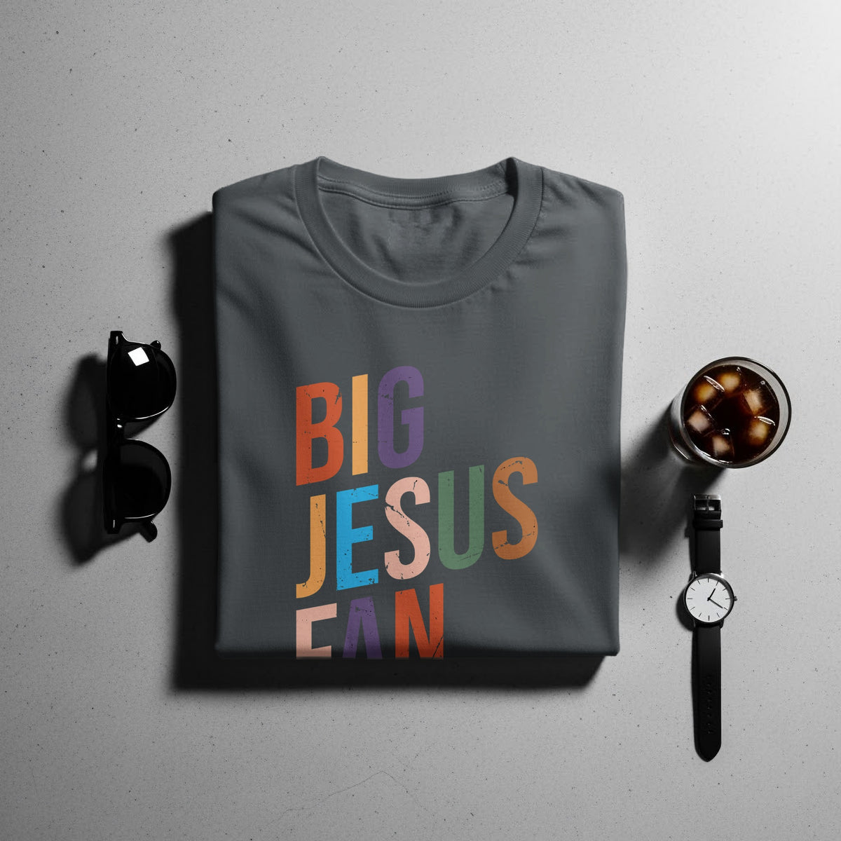 Dark grey t-shirt with "BIG JESUSCAN" text in colorful, distressed block letters.
