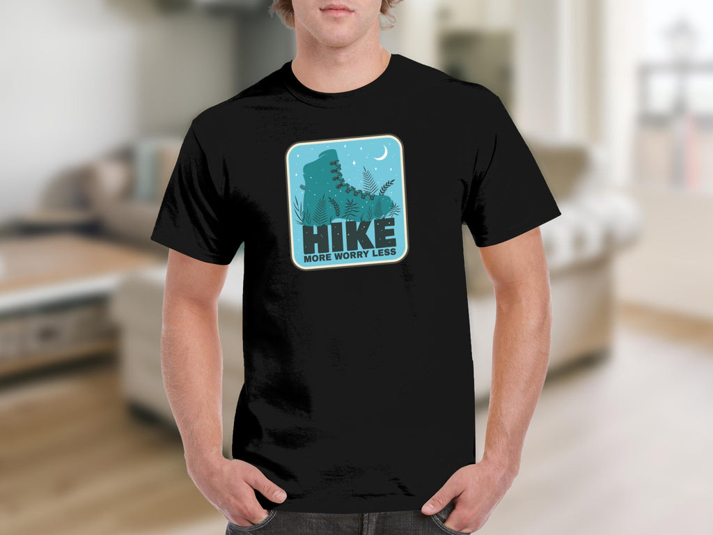 Black t-shirt with a graphic of a teal hiking boot and plants, with the words "HIKE MORE WORRY LESS."