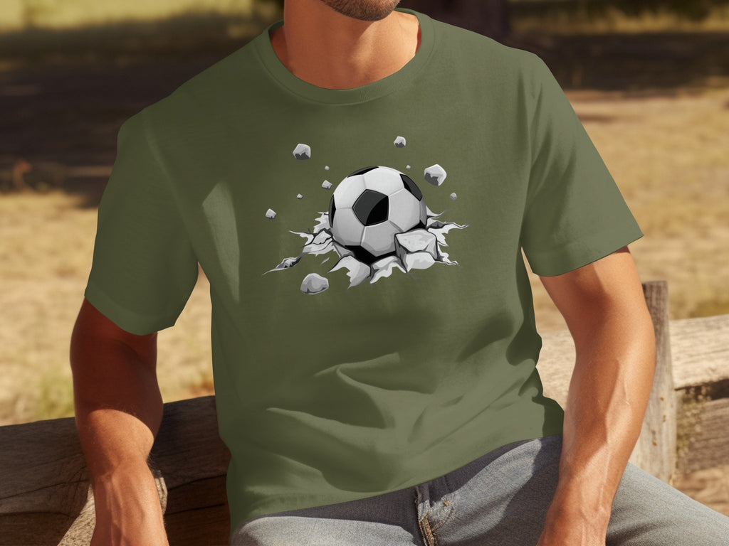 Olive green t-shirt with a graphic of a soccer ball breaking through rocks.