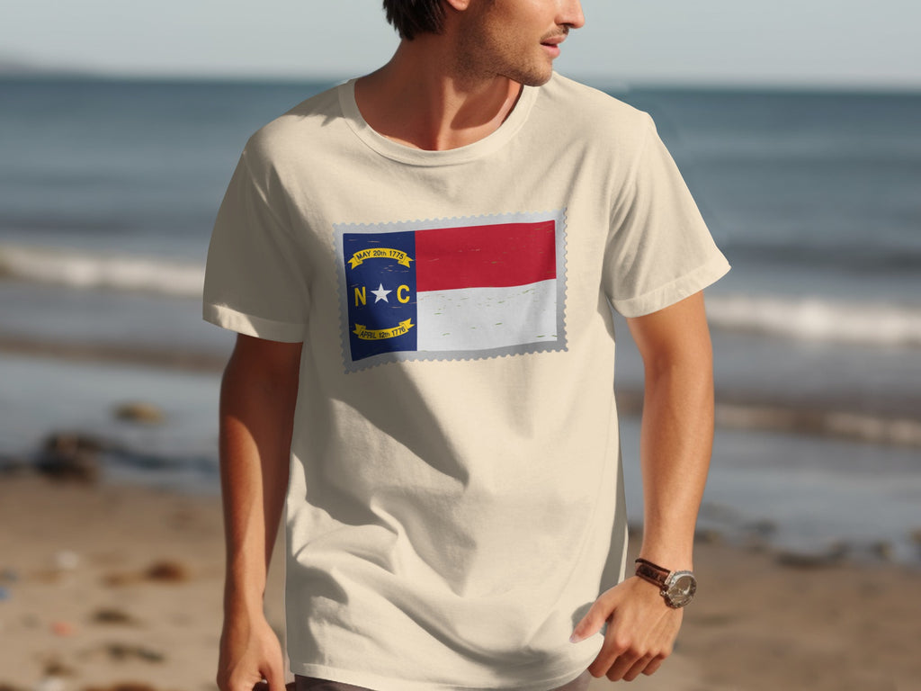 Light tan t-shirt with a North Carolina flag postage stamp graphic.