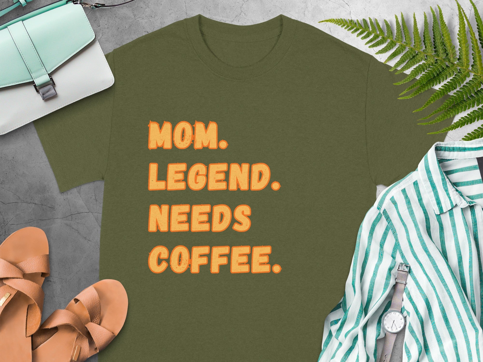 Olive green t-shirt with orange text reading "MOM. LEGEND. NEEDS COFFEE."