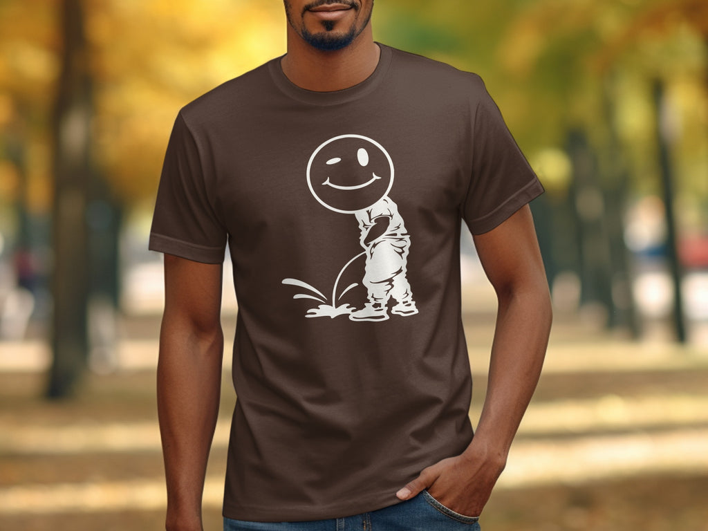Brown t-shirt with white graphic of a winking smiley face over a cartoon person urinating.