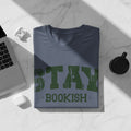 Blue t-shirt with green text "STAY BOOKISH" and a laptop.