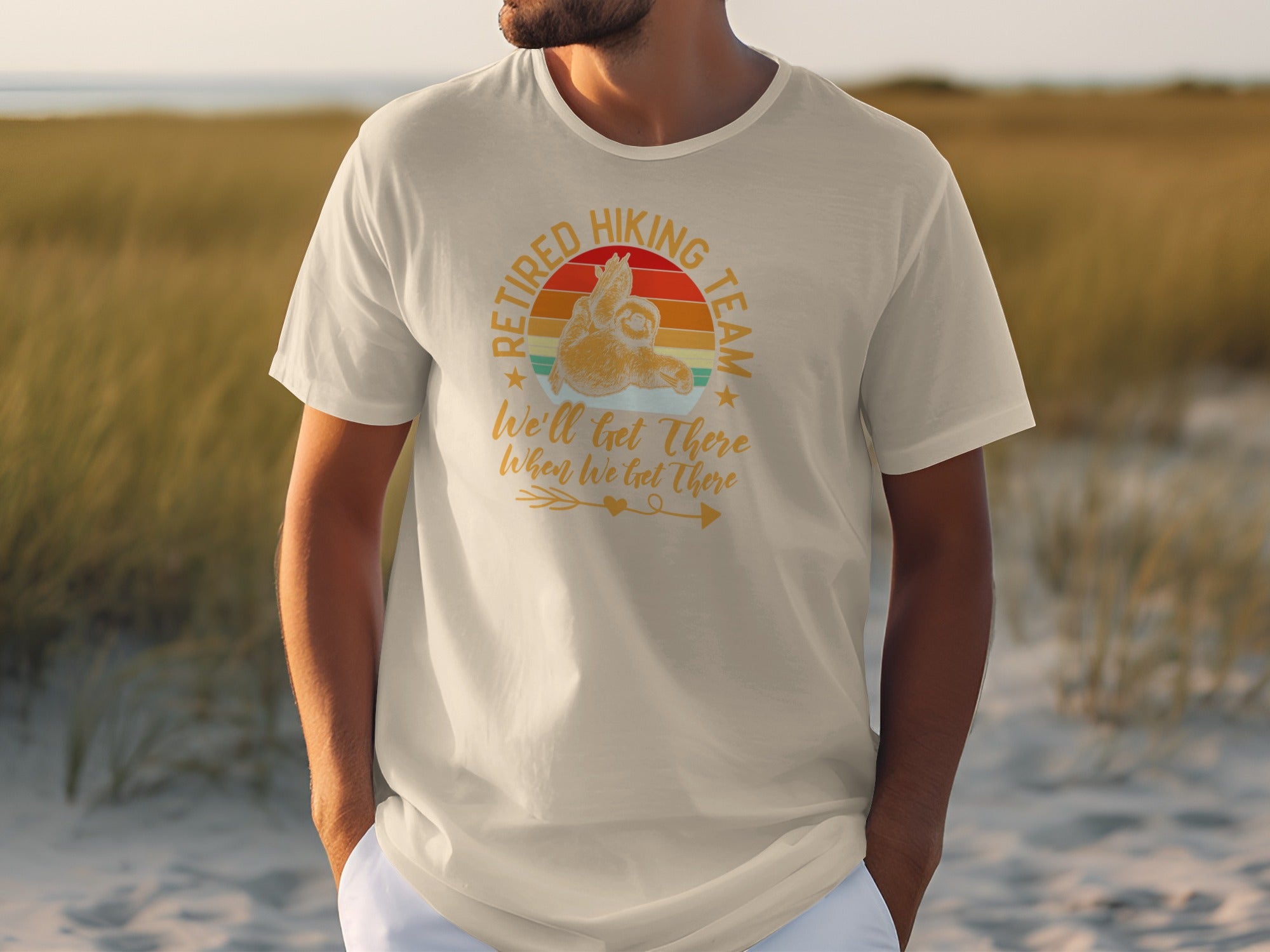 T-shirt graphic: "Retired Hiking Team" with sloth and sunset, says "We'll get there When We Get There".