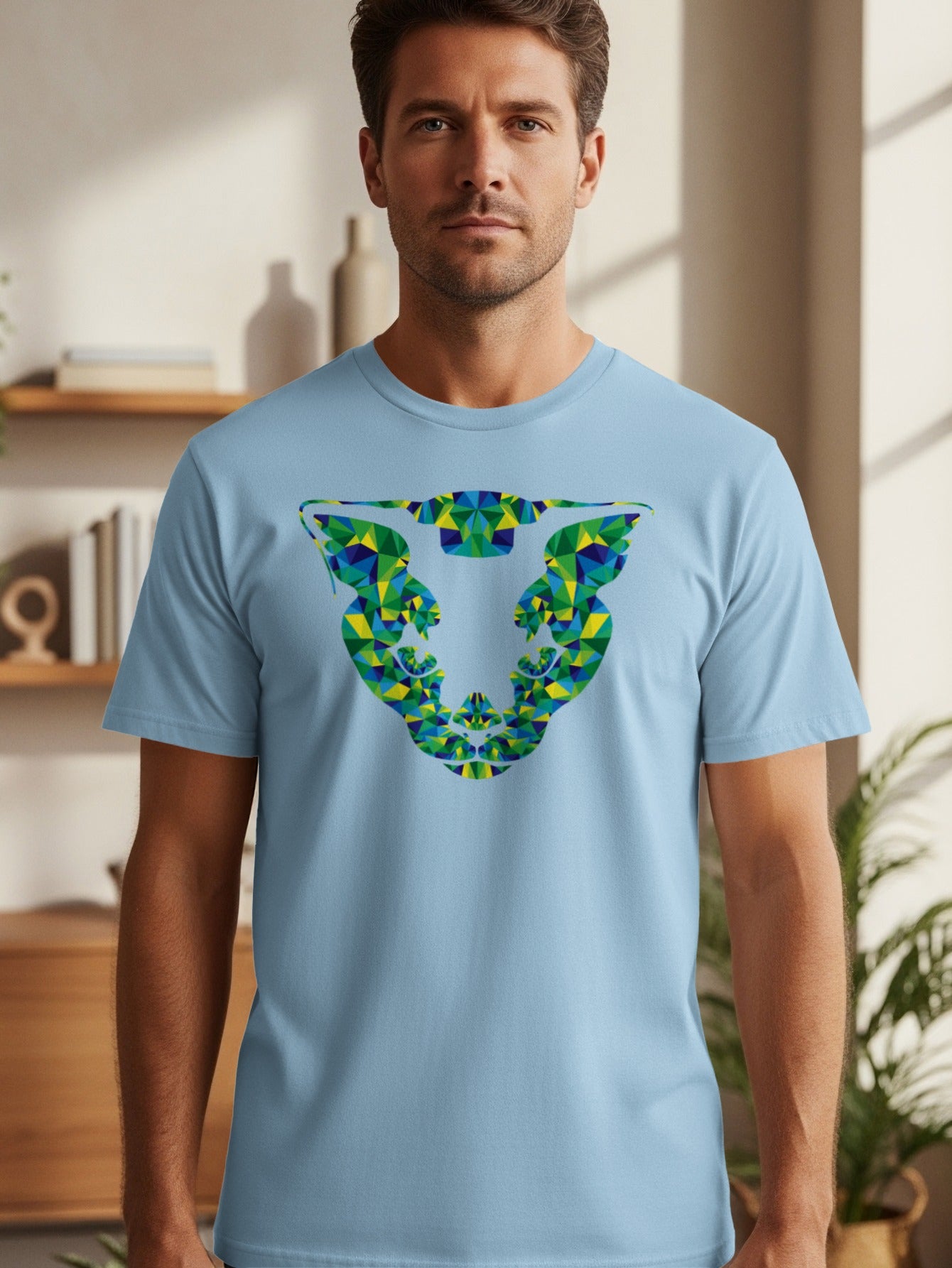 Pale blue t-shirt with a geometric fragmented print of a face in green, blue and yellow.