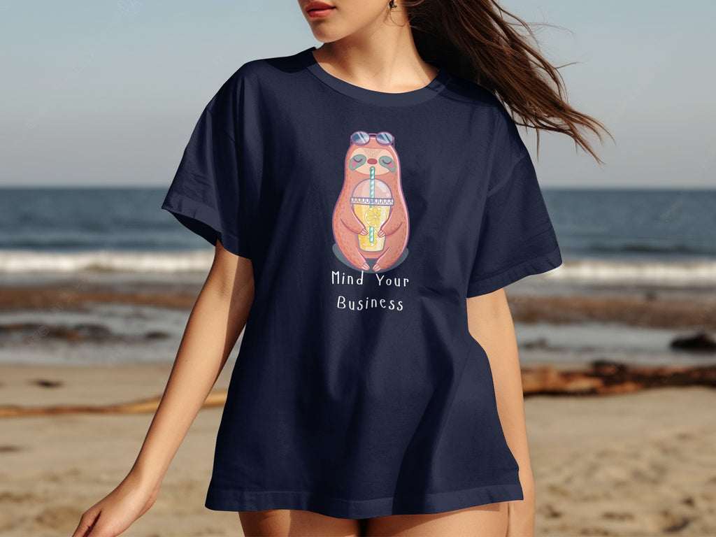 Navy t-shirt with a cartoon sloth holding a drink and sunglasses, with text "Mind Your Business."