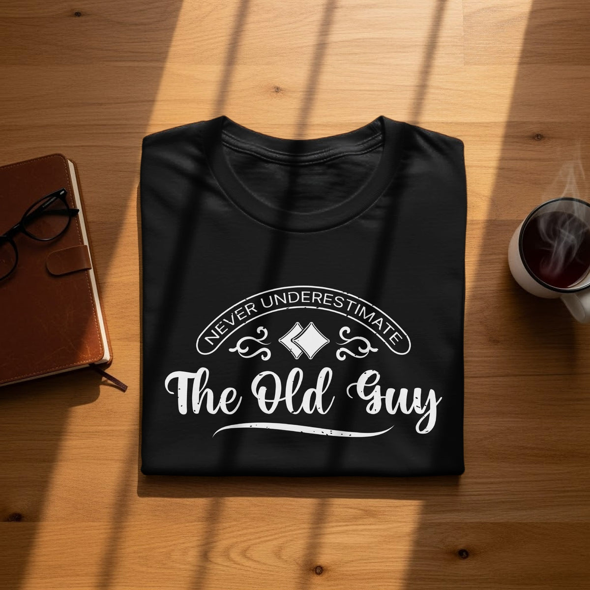 Black t-shirt with white text that reads "Never Underestimate The Old Guy".