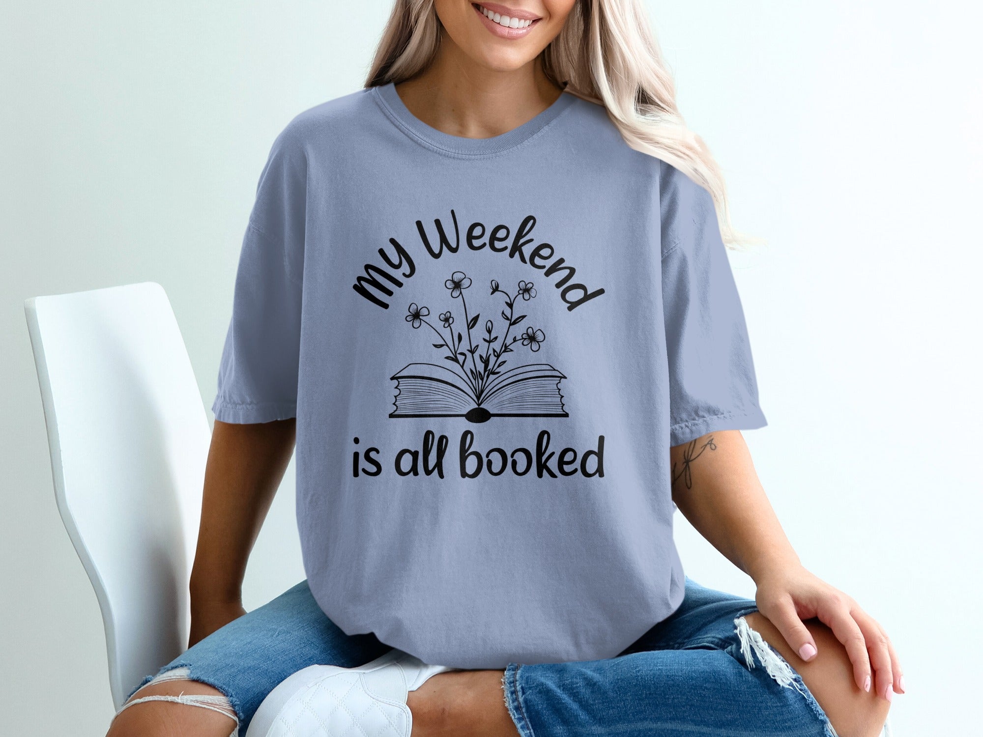 T-shirt with text "my Weekend is all booked" and an open book illustration.