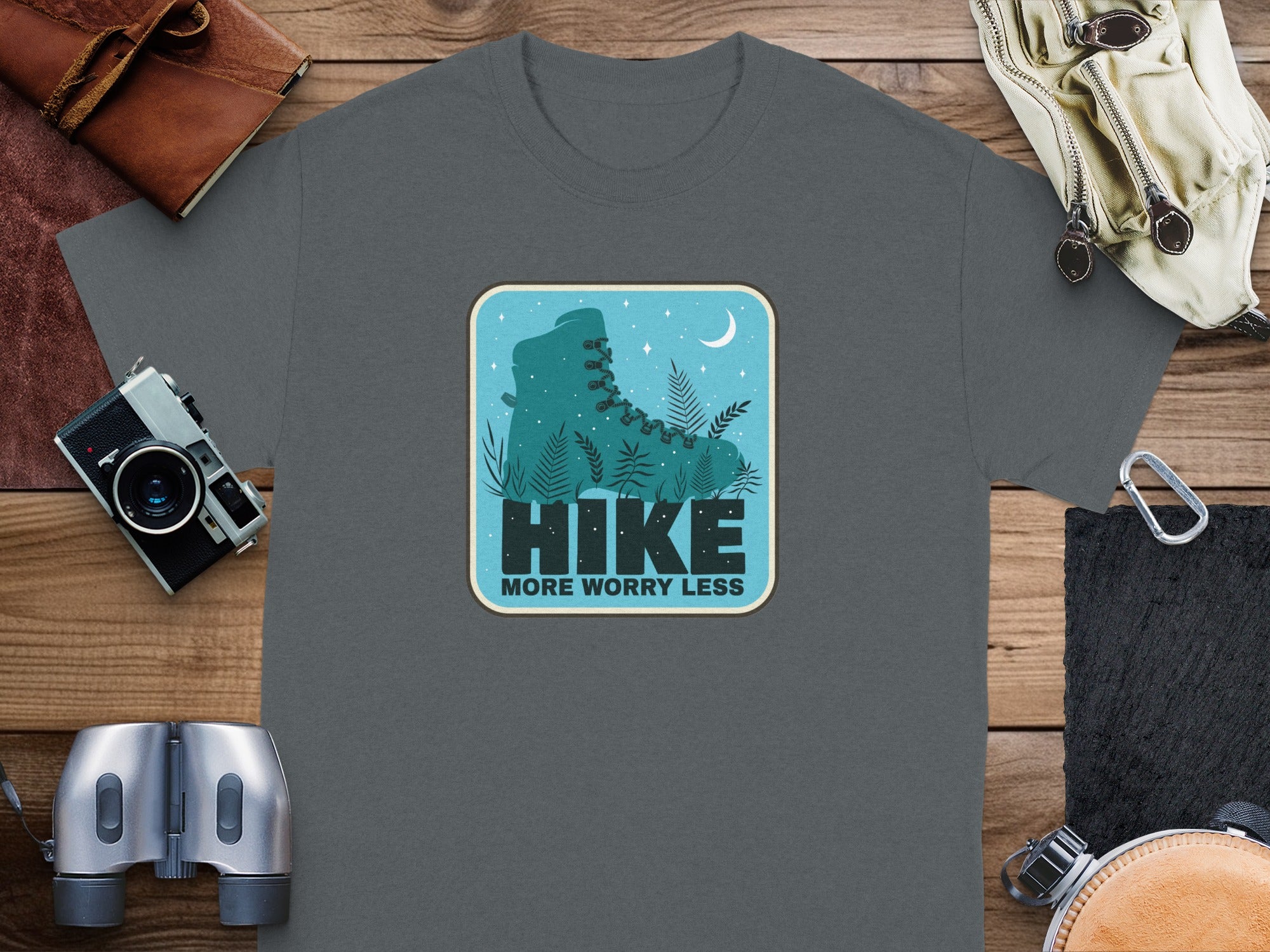 Gray t-shirt with a circular graphic of a hiking boot, ferns, moon, and stars.