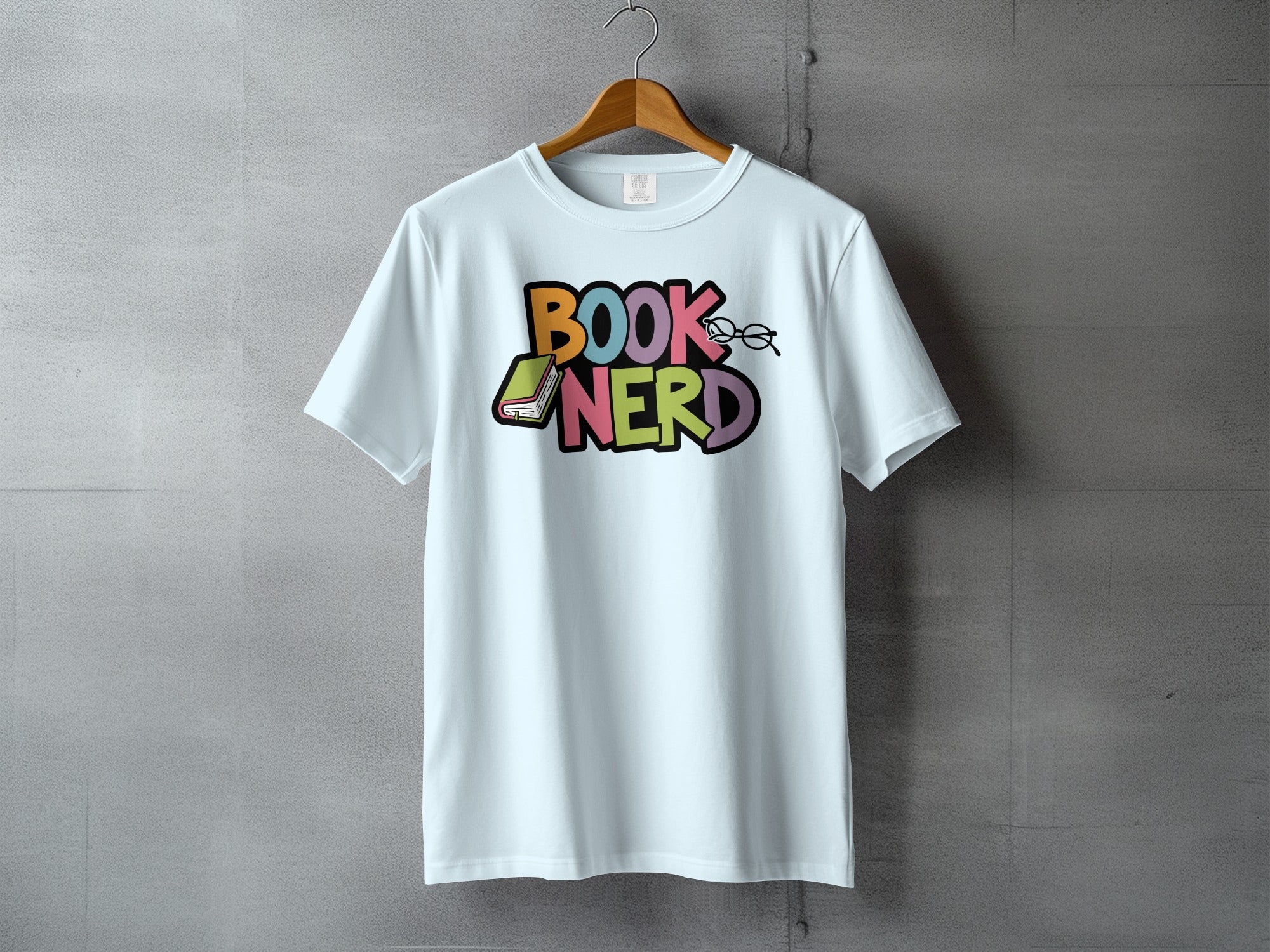 White t-shirt with "BOOK NERD" text, book, and glasses graphic.