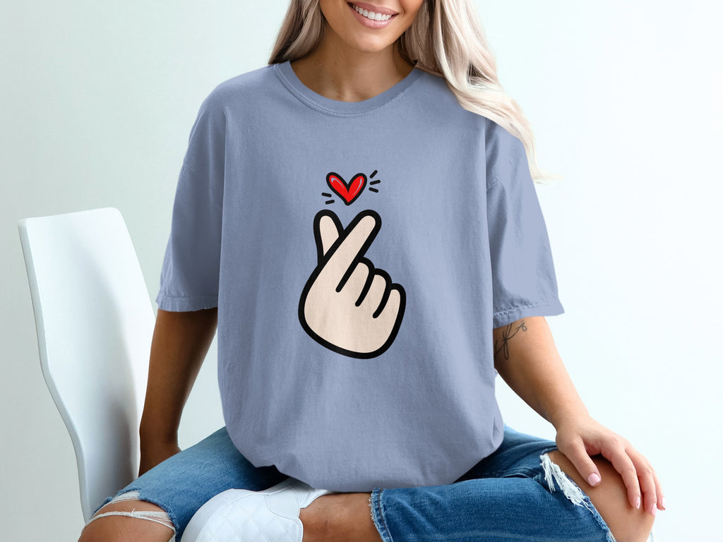 Periwinkle t-shirt with a hand gesture and small red heart graphic.