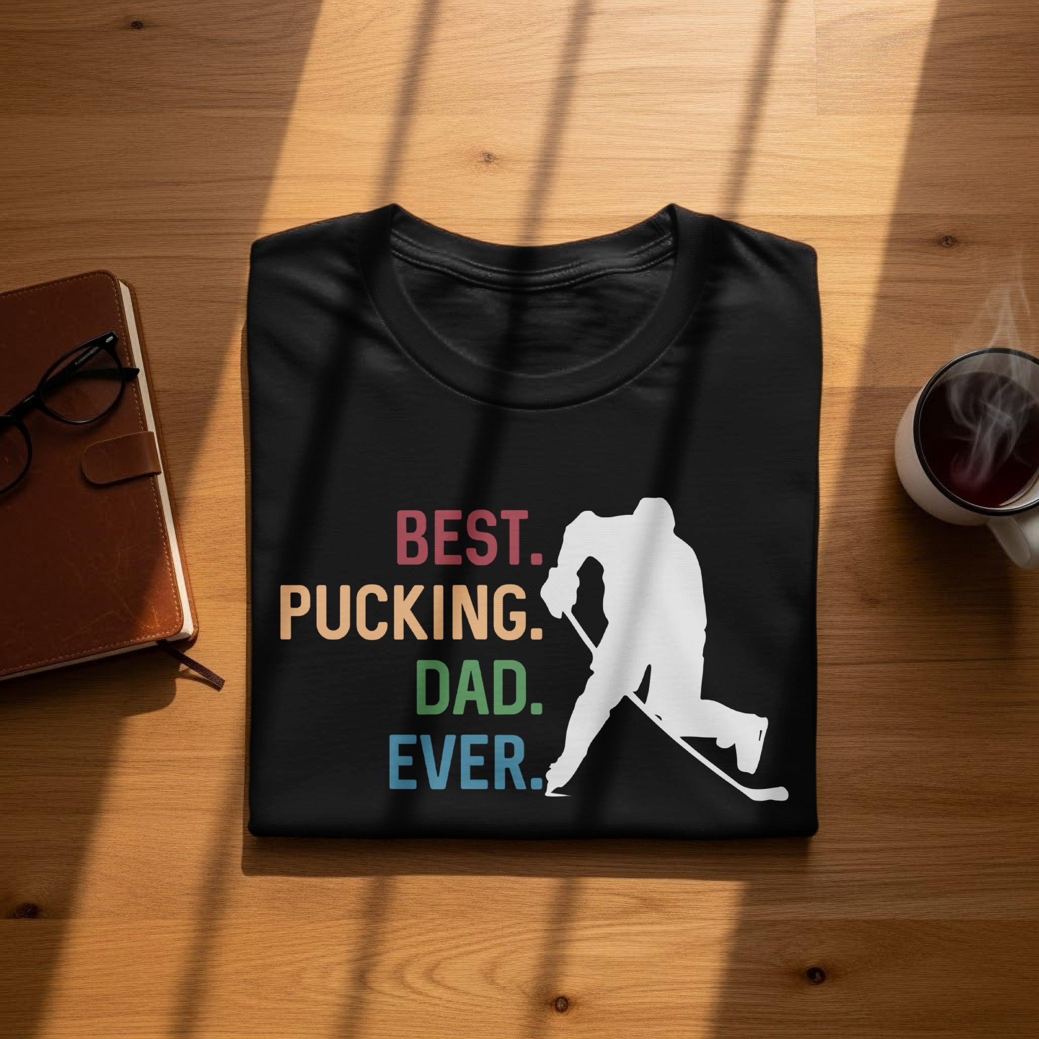 Black t-shirt with white hockey player silhouette and text: Best. Pucking. Dad. Ever.
