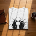 White t-shirt with a cracked black alien and galaxy design.