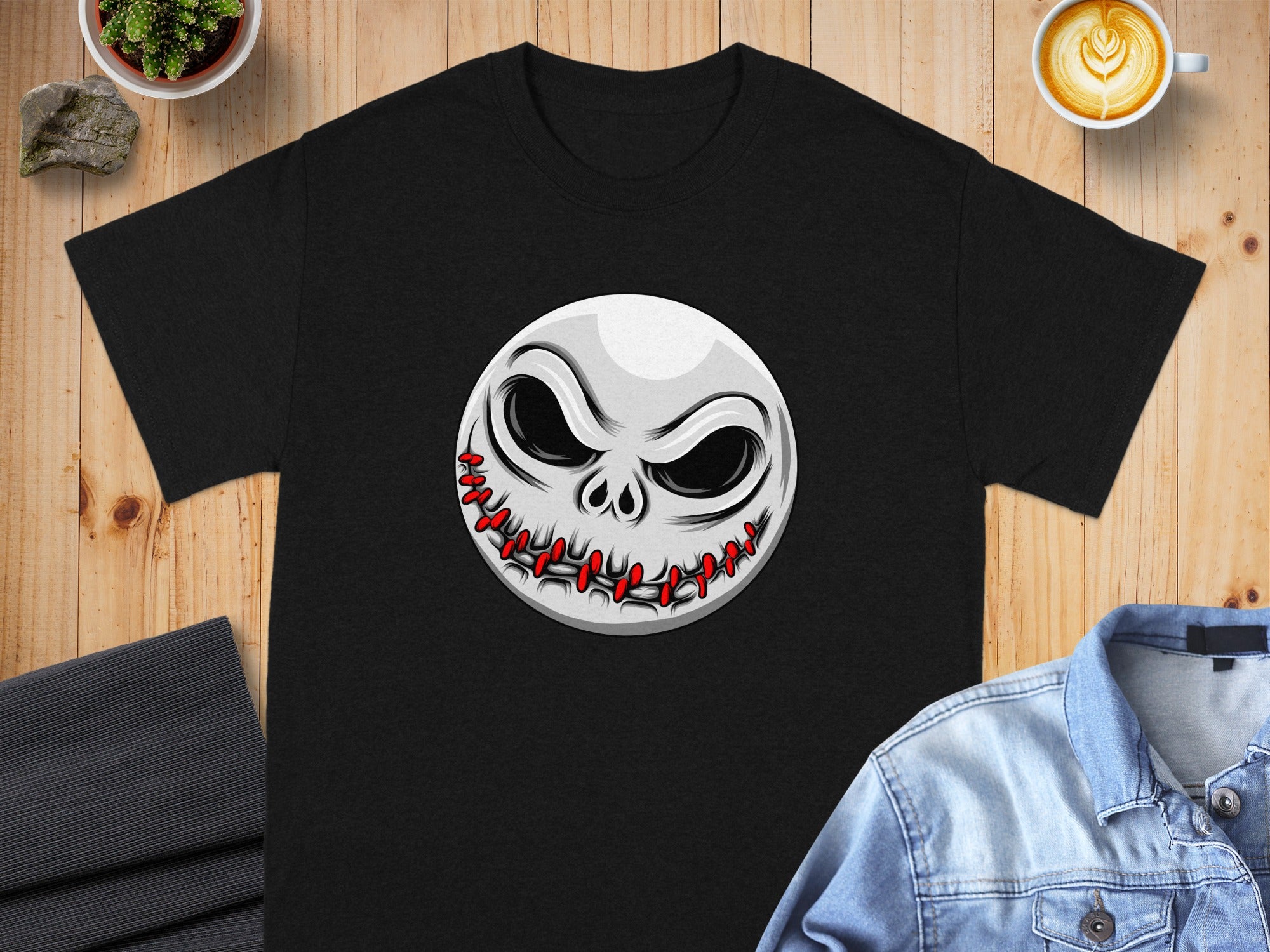 Black t-shirt featuring a circular graphic of a skull character's face with stitched mouth.