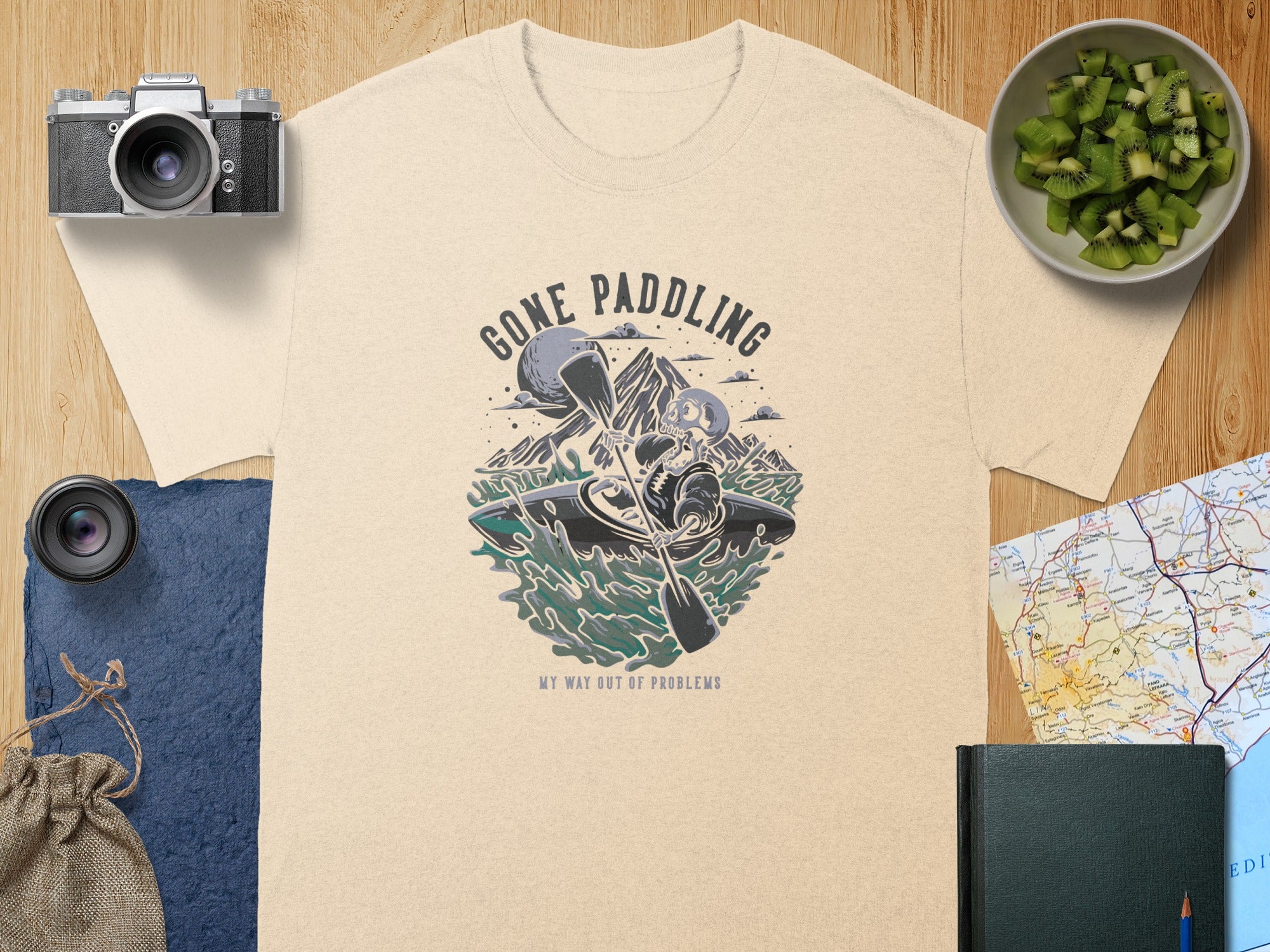 T-shirt graphic: skeleton kayaking with text "Gone Paddling" and "My Way Out of Problems."