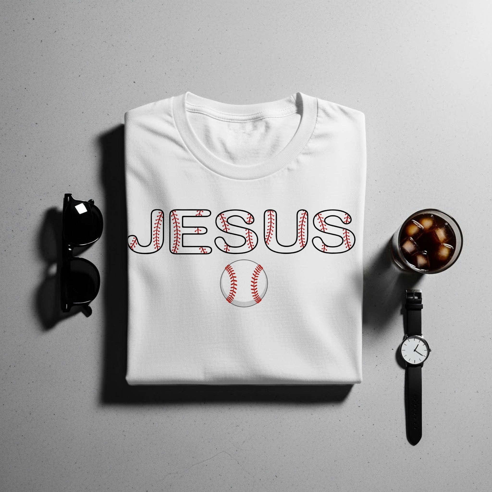 White t-shirt with "JESUS" text and baseball graphic and baseball.