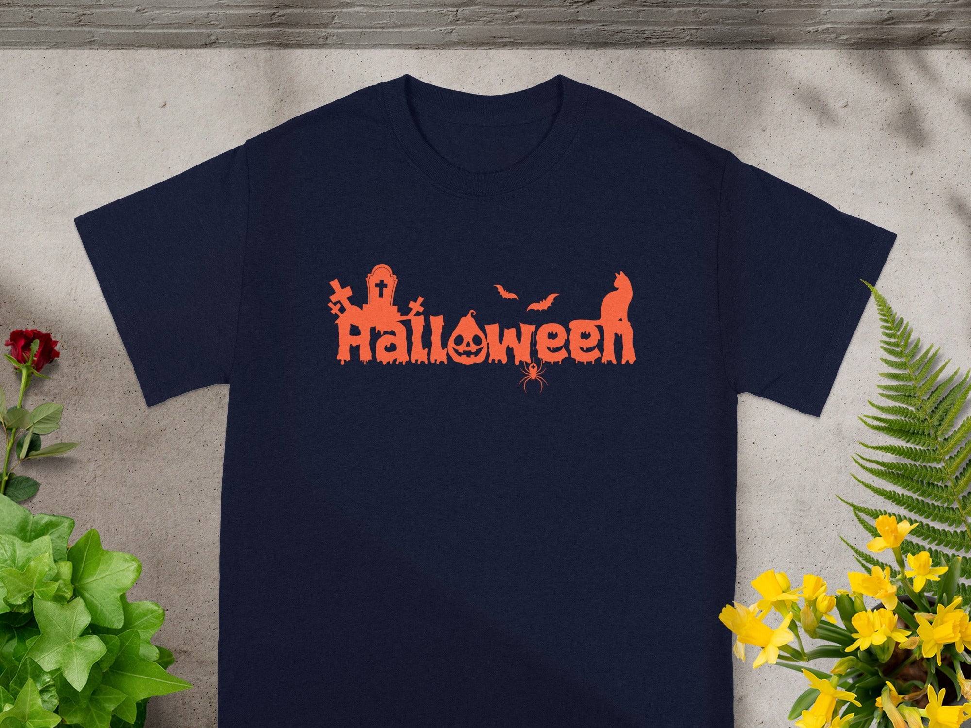 Navy t-shirt with orange Halloween graphic featuring pumpkins, bats, and a cat.