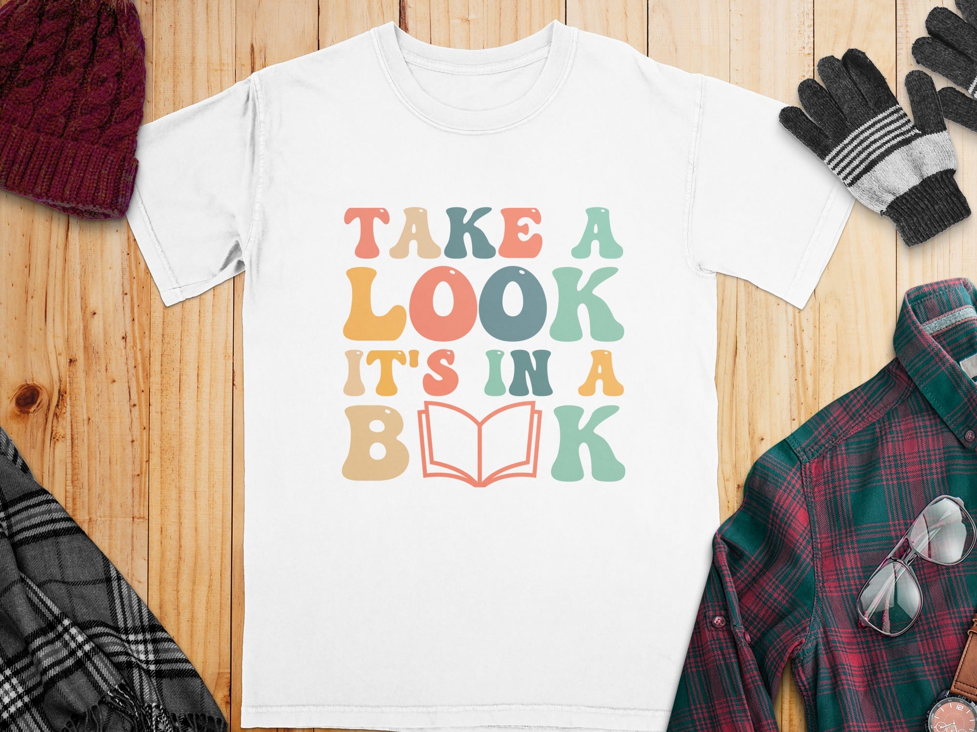 White t-shirt with "Take a Look, It's in a Book" text and an open book.