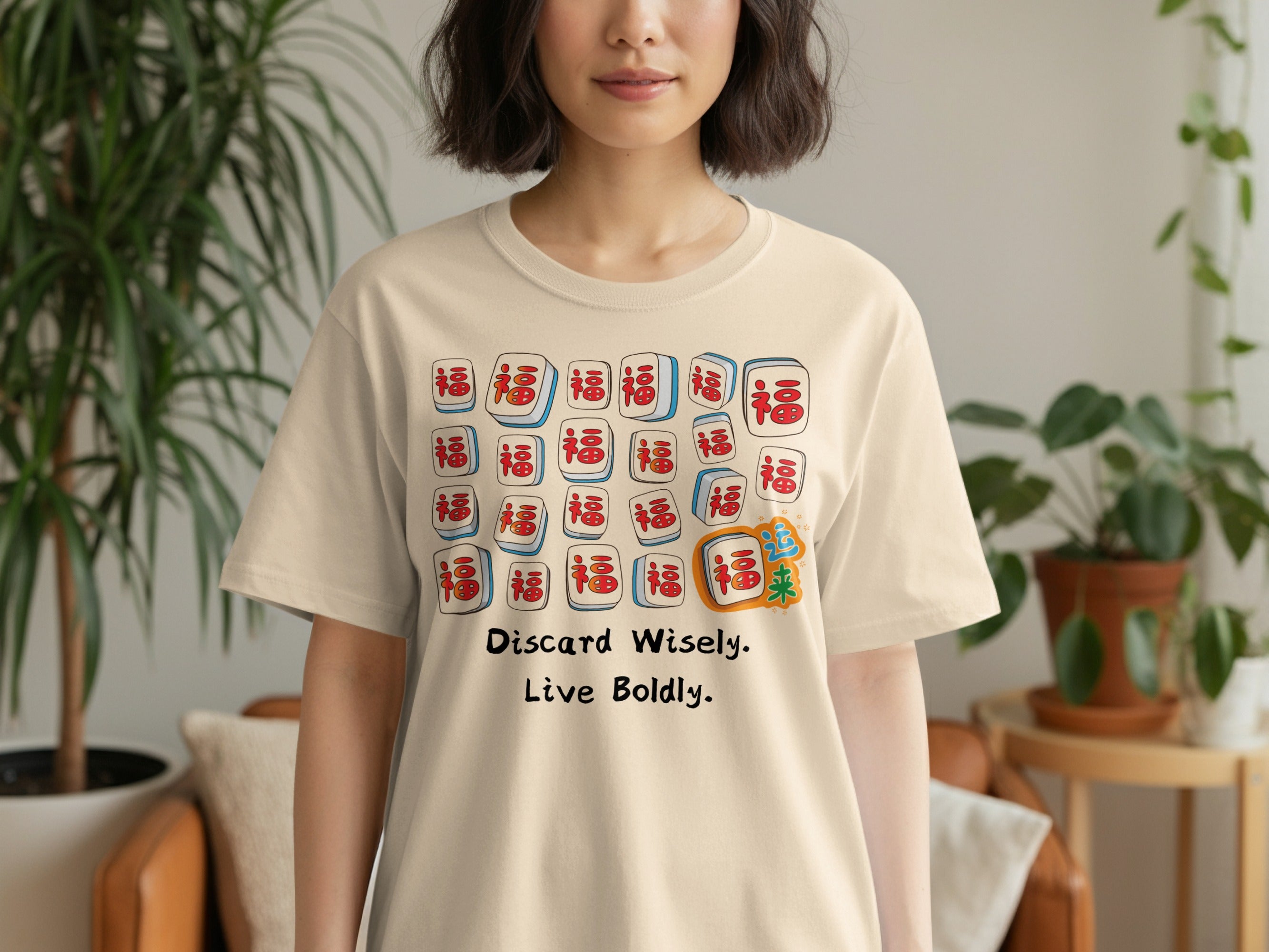 Cream t-shirt with Mahjong tiles and text "Discard Wisely. Live Boldly."