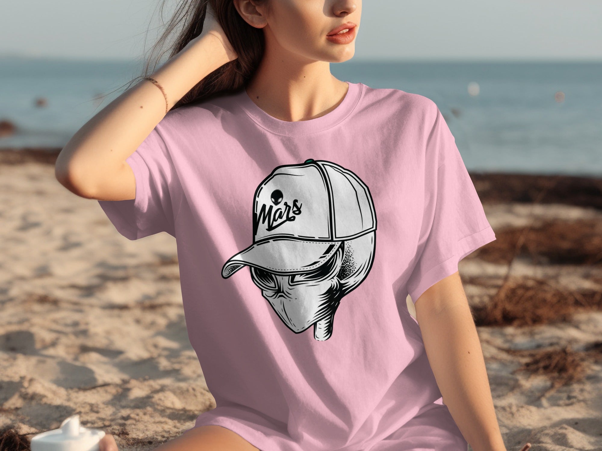 Pink t-shirt with graphic of alien wearing cap that says "Mars"