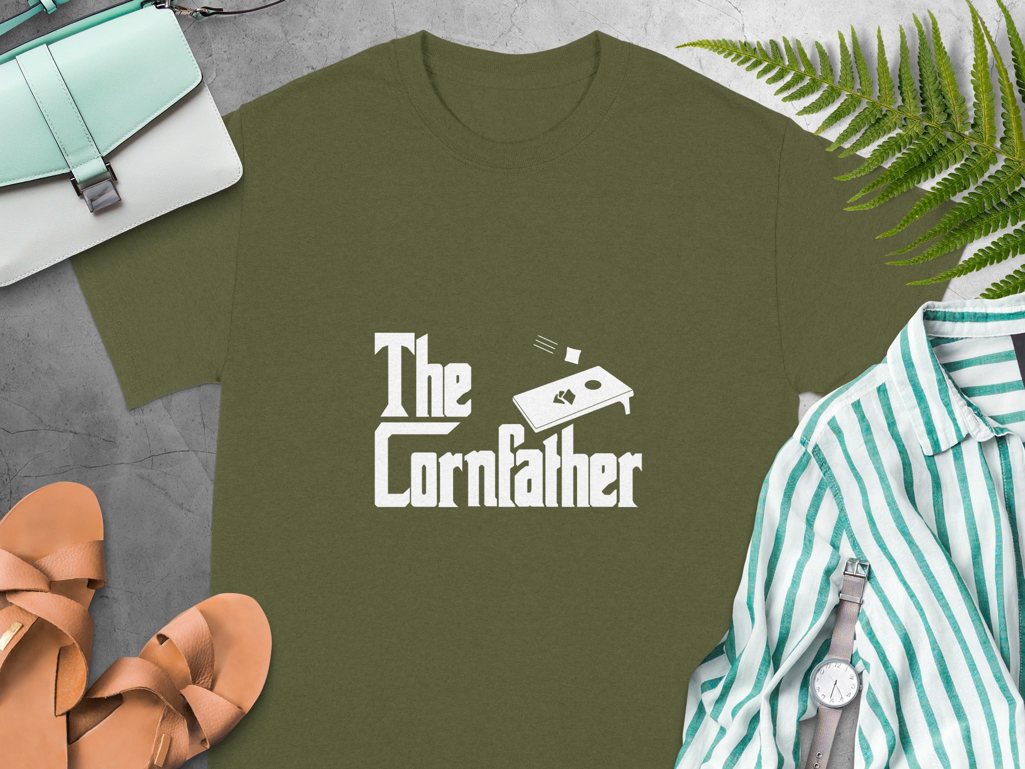 Green t-shirt with "The Cornfather" logo and cornhole graphic.