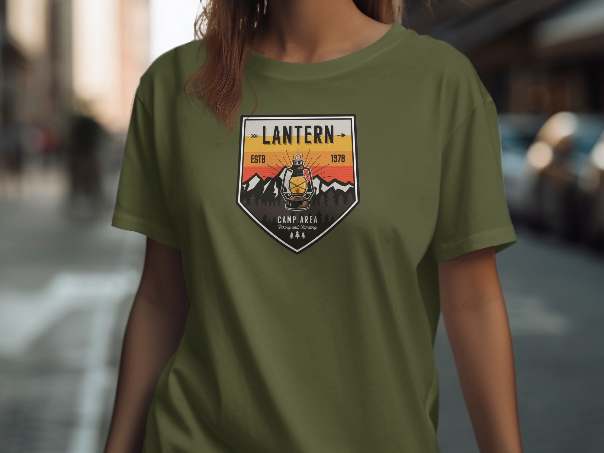 Olive green t-shirt with "Lantern Camp Area" badge featuring a lantern, mountains, and trees.