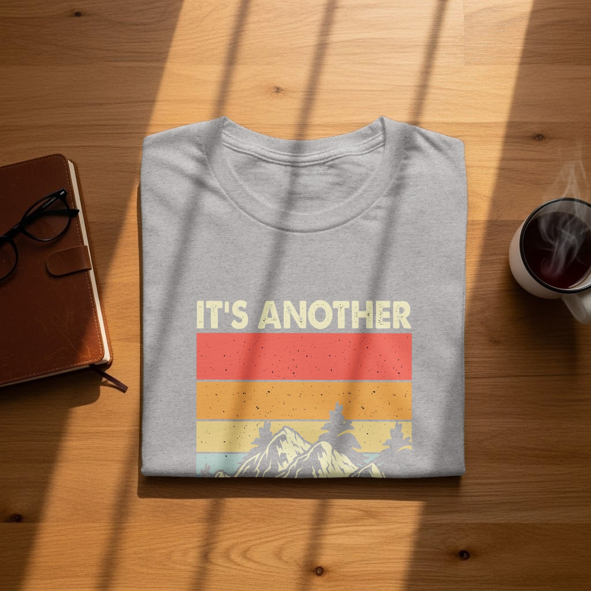 Gray t-shirt with "IT'S ANOTHER" text and vintage mountain graphic.