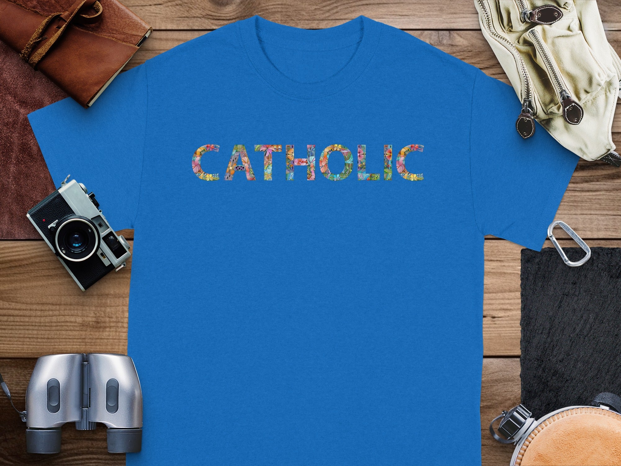 Blue t-shirt with "CATHOLIC" in colorful floral letters.