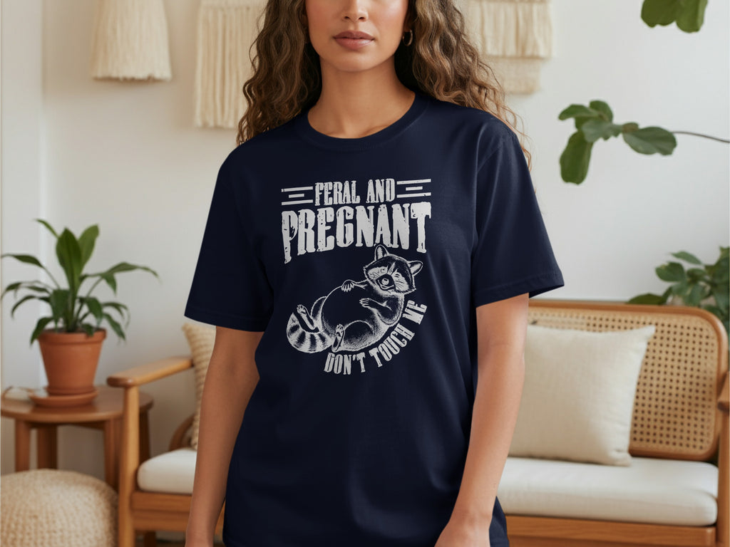 Navy t-shirt with distressed text "FERAL AND PREGNANT" and a raccoon illustration.