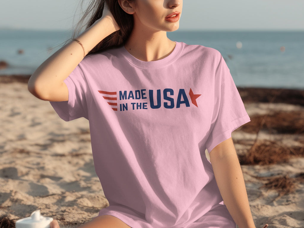 Pink t-shirt with "MADE IN THE USA" text and US flag accents.