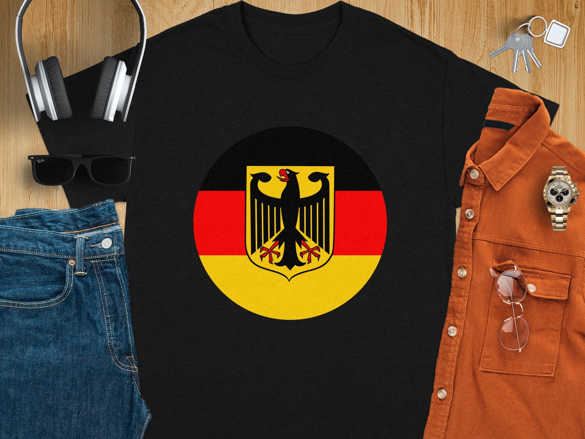 Black t-shirt with German flag emblem, sunglasses, headphones, jeans, and orange shirt.