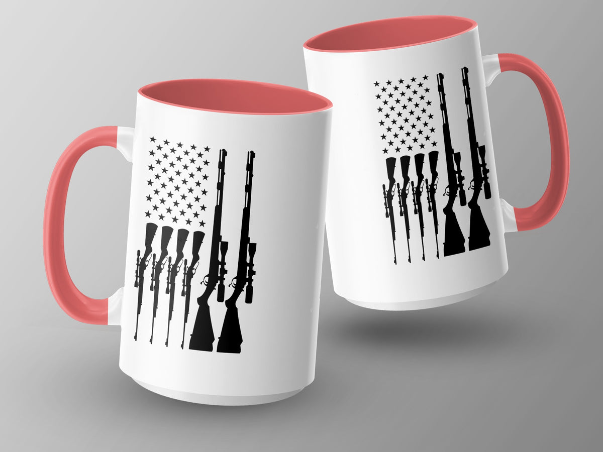 Two white mugs with coral handles and rims, featuring black American flag and rifle graphics.