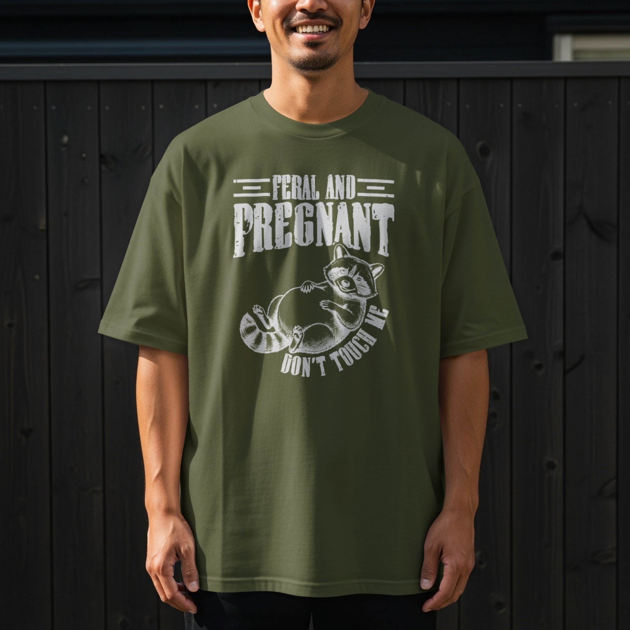Green t-shirt with raccoon graphic and text "Feral and Pregnant Don't Touch Me"