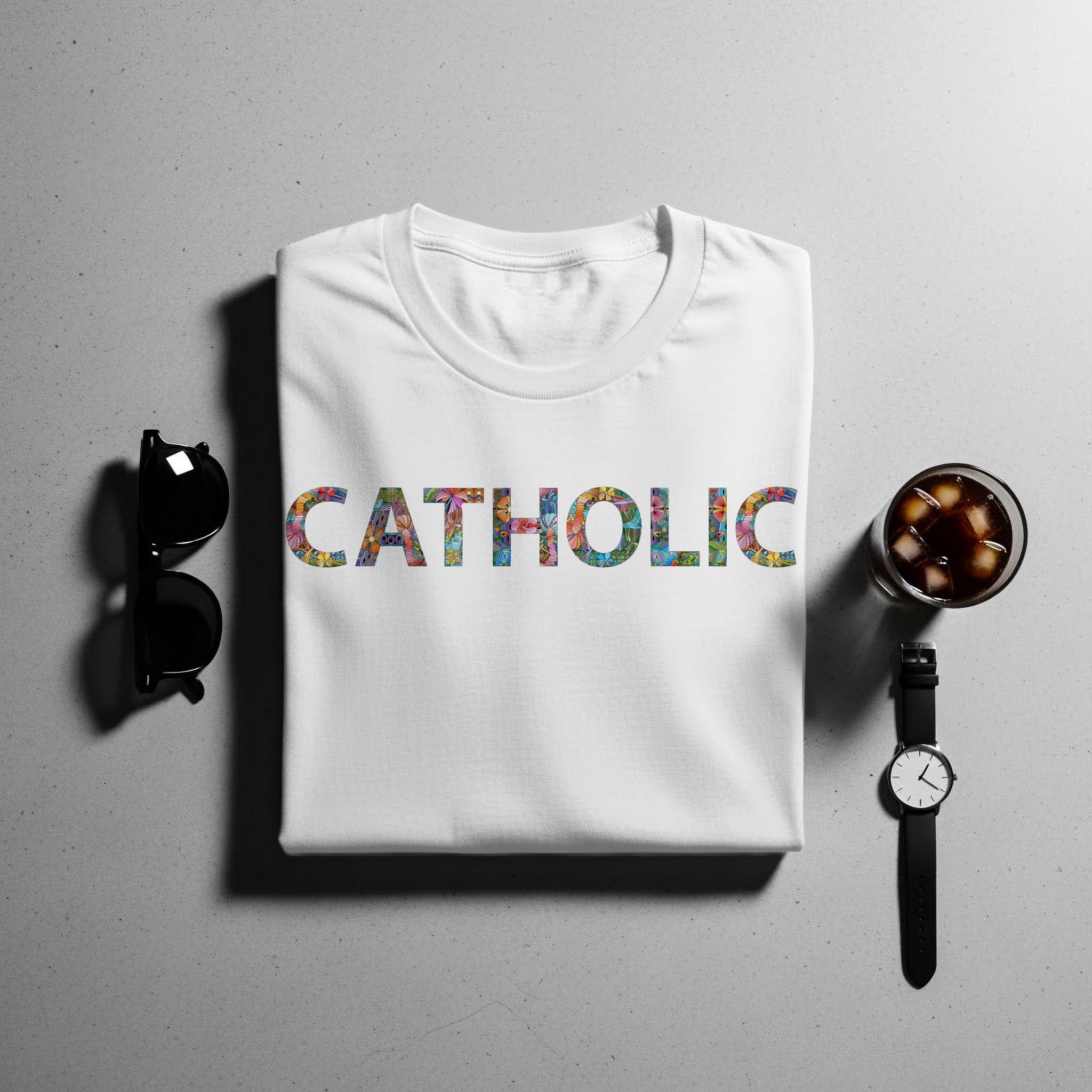 White t-shirt with "CATHOLIC" text in colorful floral pattern.