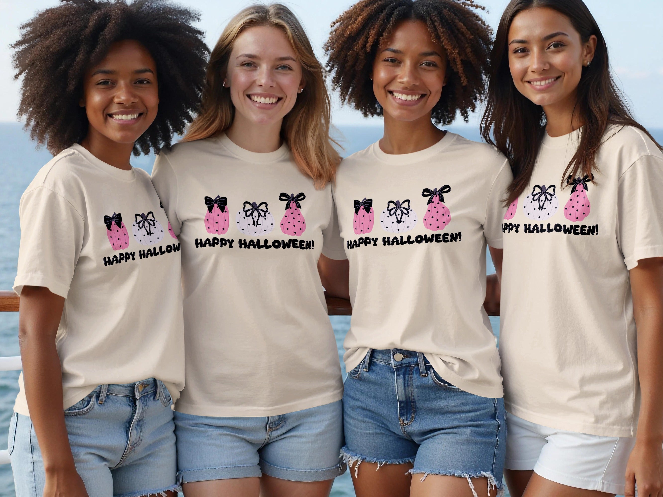 Four women wear graphic tees with pink and white pumpkins and the text "Happy Halloween!".